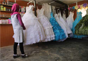 فتاة في الرابعة عشر من عمرها في محل لبيع فساتين الأعراس في مخيم الزعتري للاجئيين السوريين 
