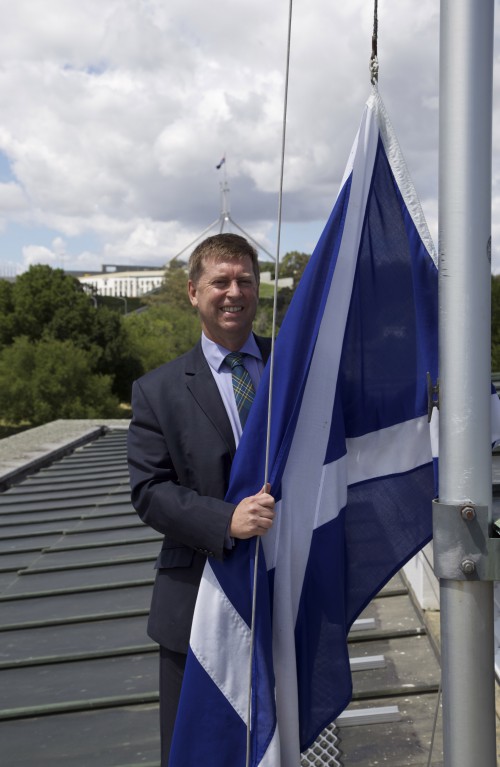 HE Paul Madden with Saltire on roof of the British High Commission, Canberra