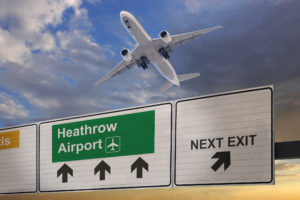 Road sign indicating the direction of Heathrow airport and a plane that just got up.